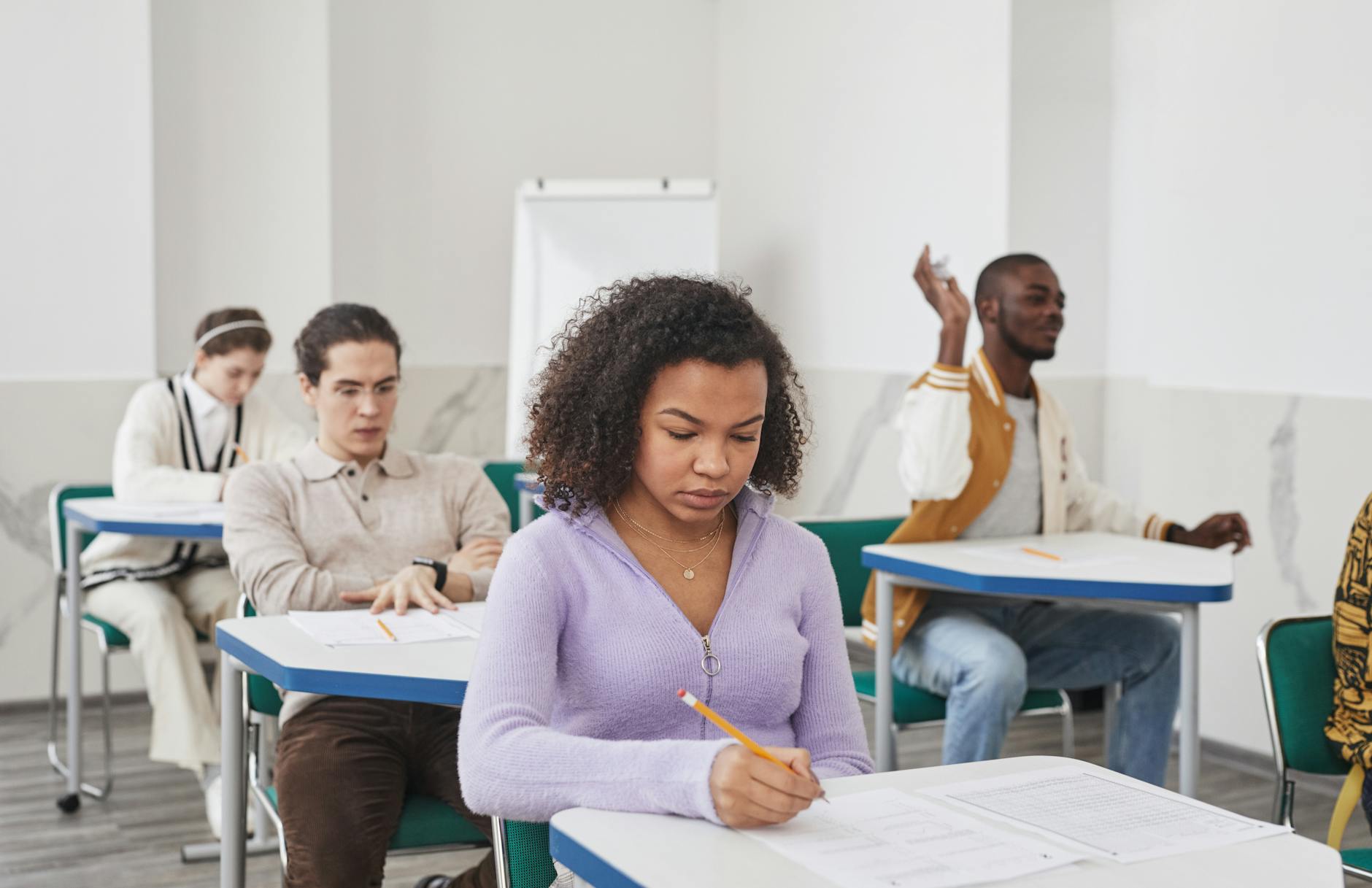 Uczniowie różnych narodowości piszą test w szkolnej sali