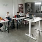 Uczniowie słuchający nauczyciela podczas lekcji w nowoczesnej klasie