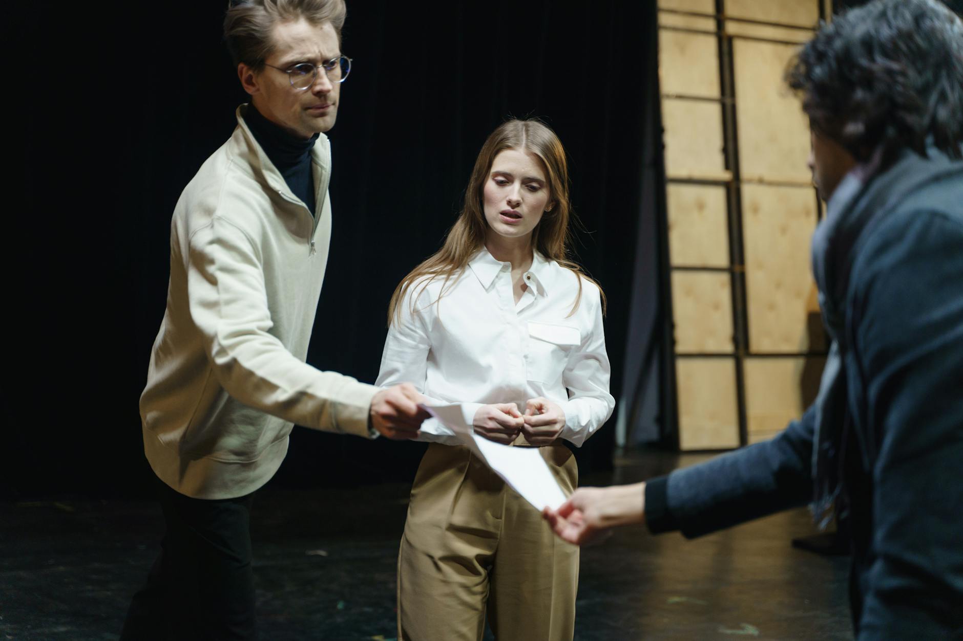 Aktorzy na scenie podczas próby, z tekstami sztuki w rękach