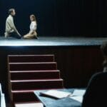 Aktorzy podczas dramatycznej próby sceny na przyciemnionej scenie teatru
