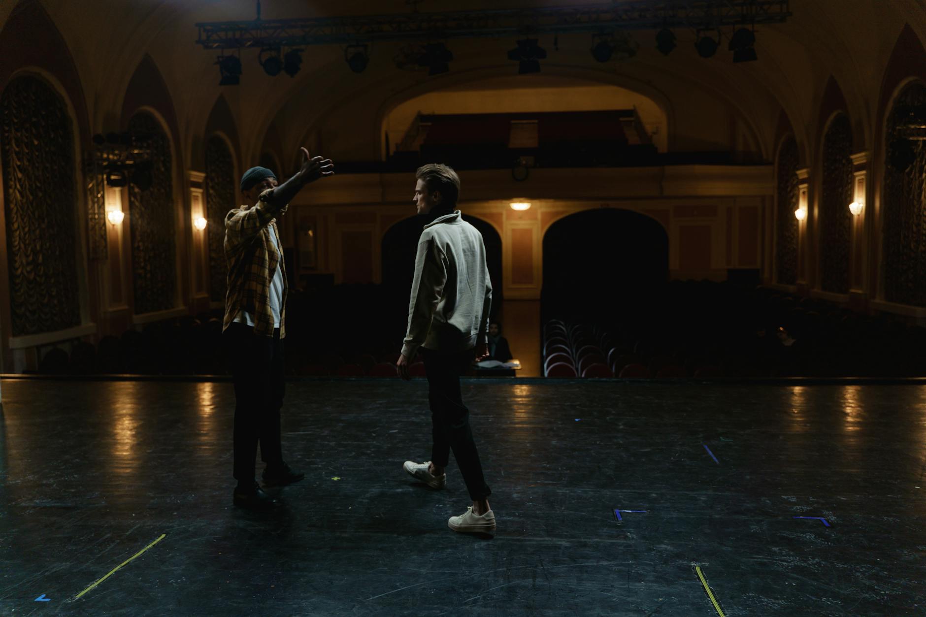 Dwóch aktorów na pustej scenie teatralnej podczas próby sceny