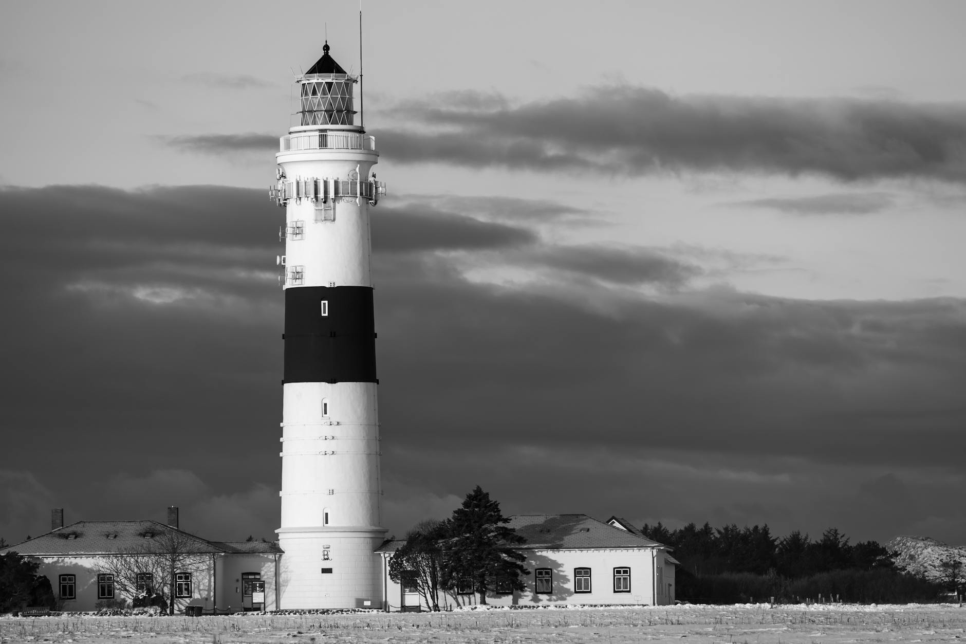 Czarno-białe ujęcie latarni morskiej w Kampen na tle pochmurnego nieba