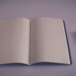 Otwarty notes z długopisem na pustej stronie, gotowy do pisania prosto