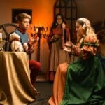 Aktorzy jako Romeo i Julia na scenie w renesansowych strojach przy świecach