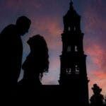 Sylwetki zakochanej pary o zachodzie słońca na tle kościoła w Guanajuato
