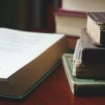 Stos starych książek ułożonych na drewnianym stole