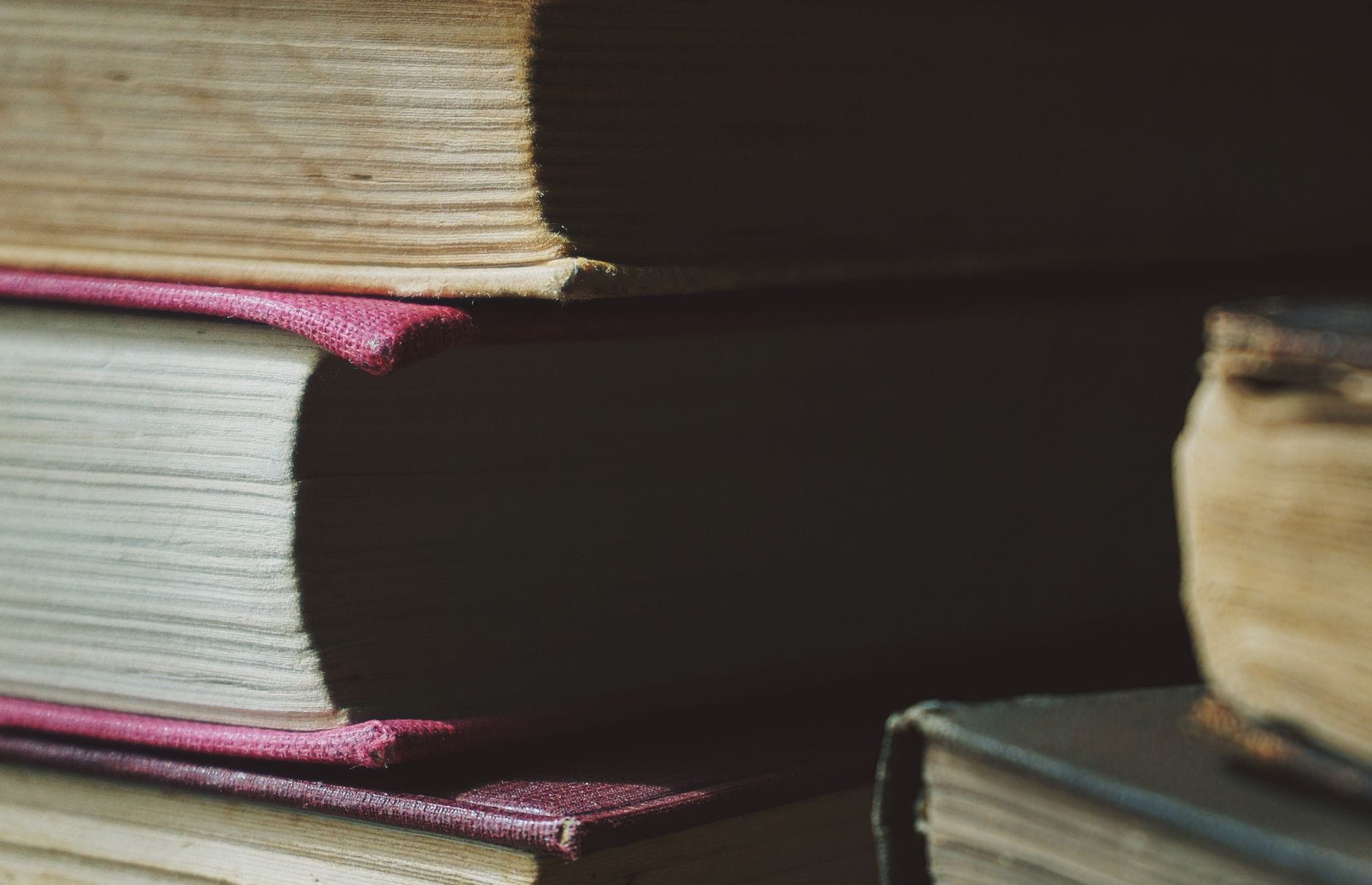 Stos starych książek w twardych oprawach związanych z literaturą